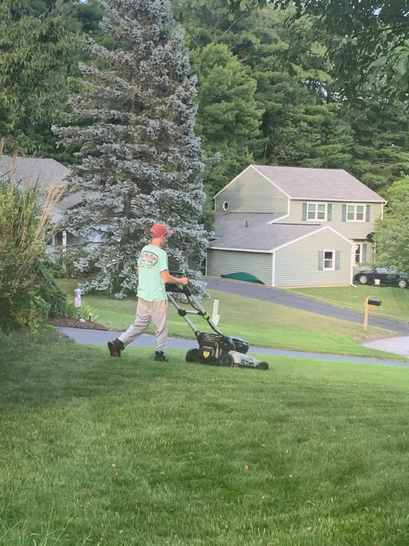 Nate at age 12 mowing a Clifton Park lawn in 2020, the first season of the business
