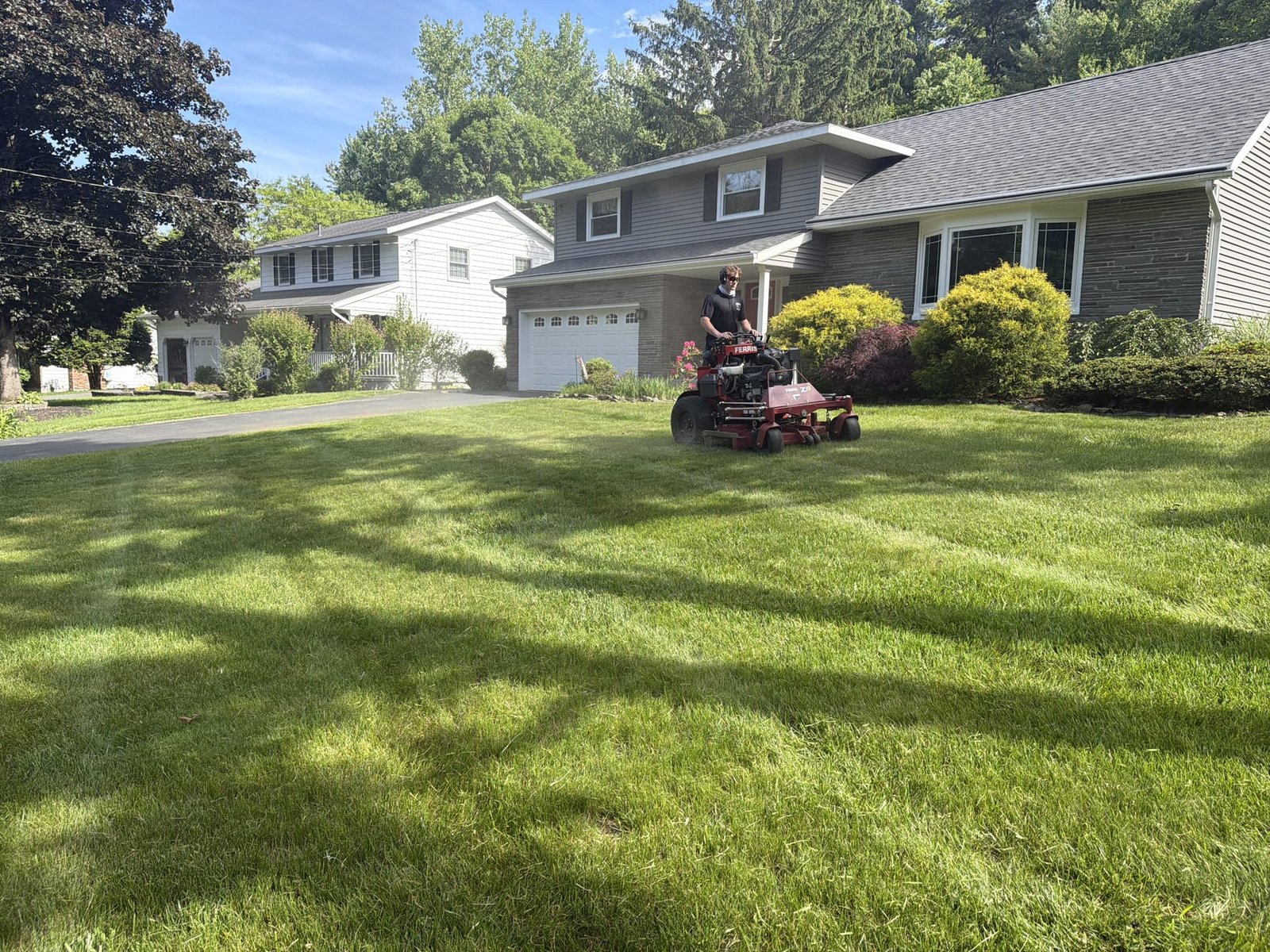 Toro zero-turn mid-cut on a striped Capital Region front lawn with colonial home